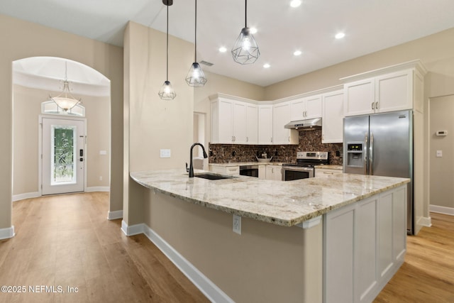 86569 N Hampton Club Way, Fernandina Beach, FL 32034 - kitchen featuring stainless steel appliances, under cabinet range hood, a sink, backsplash, and light stone counters