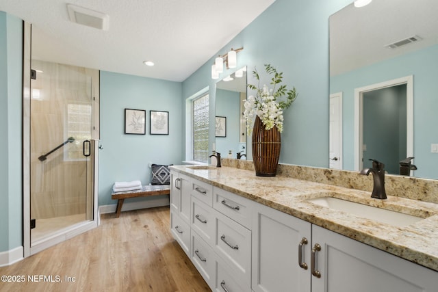 86569 N Hampton Club Way, Fernandina Beach, FL 32034 - full bath with double vanity, a shower stall, wood finished floors, recessed lighting, and baseboards
