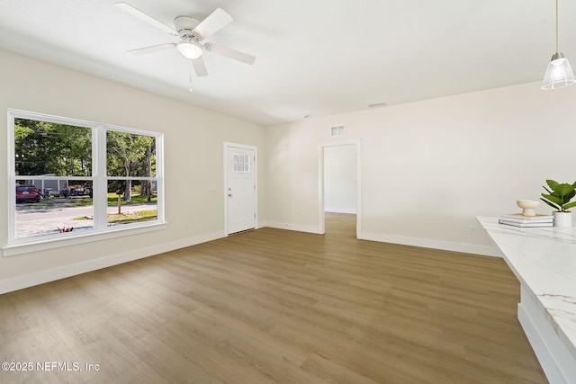 763 W 4th St, Saint Augustine, FL 32084 - unfurnished living room featuring light wood-type flooring, baseboards, and ceiling fan