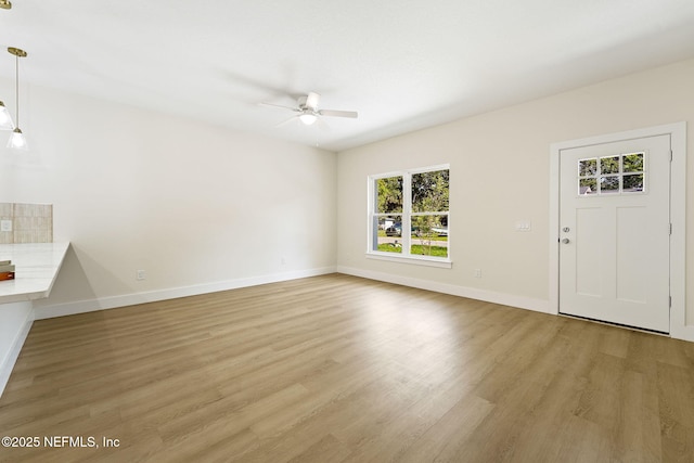 763 W 4th St, Saint Augustine, FL 32084 - unfurnished living room featuring healthy amount of natural light, a ceiling fan, light wood-type flooring, and baseboards
