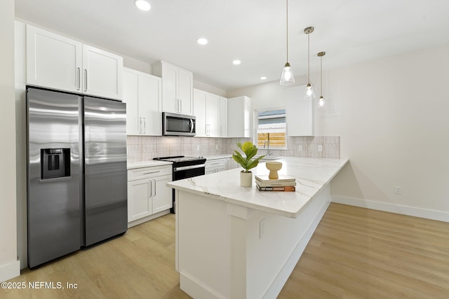 763 W 4th St, Saint Augustine, FL 32084 - kitchen featuring appliances with stainless steel finishes, white cabinetry, a peninsula, decorative backsplash, and recessed lighting