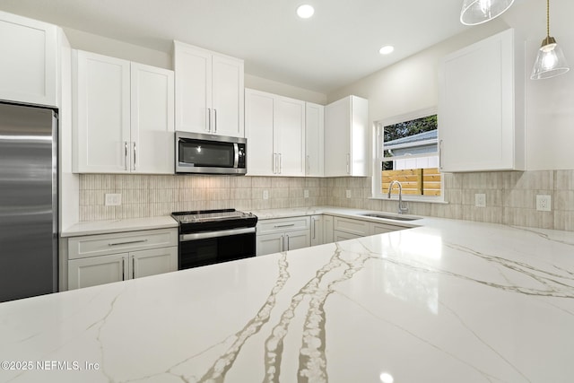 763 W 4th St, Saint Augustine, FL 32084 - kitchen with stainless steel appliances, a sink, white cabinets, pendant lighting, and recessed lighting