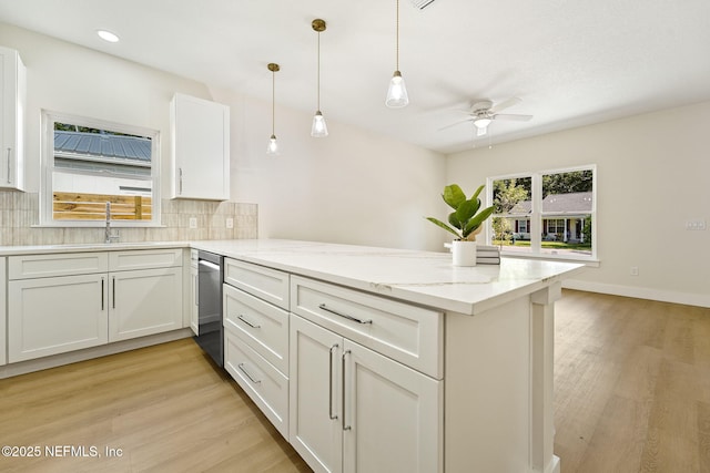 763 W 4th St, Saint Augustine, FL 32084 - kitchen with stainless steel dishwasher, a peninsula, a ceiling fan, tasteful backsplash, and light wood-style floors