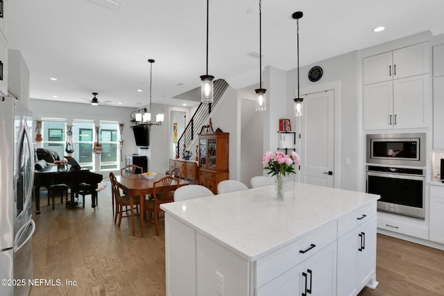 1622 Bridgeton Dr, Jacksonville, FL 32207 - kitchen featuring stainless steel appliances, light wood finished floors, a center island, hanging light fixtures, and recessed lighting