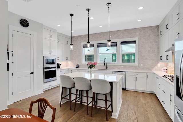 1622 Bridgeton Dr, Jacksonville, FL 32207 - kitchen with stainless steel appliances, light wood finished floors, a breakfast bar, a sink, and backsplash