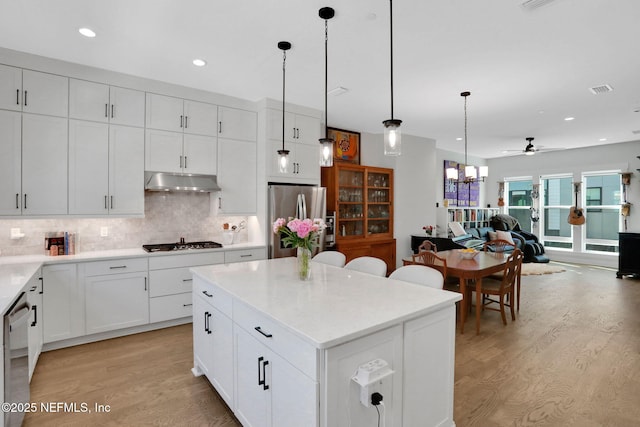 1622 Bridgeton Dr, Jacksonville, FL 32207 - kitchen with appliances with stainless steel finishes, under cabinet range hood, light wood-style flooring, a ceiling fan, and tasteful backsplash