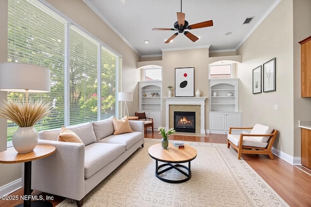 2347 W Clovelly Ln, Saint Augustine, FL 32092 - living area with light wood finished floors, ceiling fan, a fireplace with flush hearth, crown molding, and baseboards