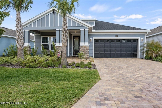 50 Dollar Ct, Saint Augustine, FL 32092 - view of front of property with a front lawn, a garage, decorative driveway, board and batten siding, and stone siding