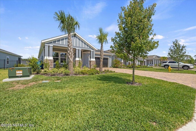 50 Dollar Ct, Saint Augustine, FL 32092 - view of front of property with decorative driveway, stone siding, a garage, and board and batten siding