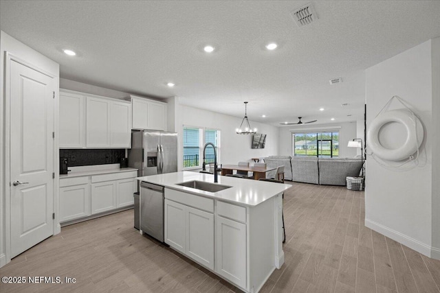 50 Dollar Ct, Saint Augustine, FL 32092 - kitchen featuring a sink, appliances with stainless steel finishes, open floor plan, light countertops, and white cabinets