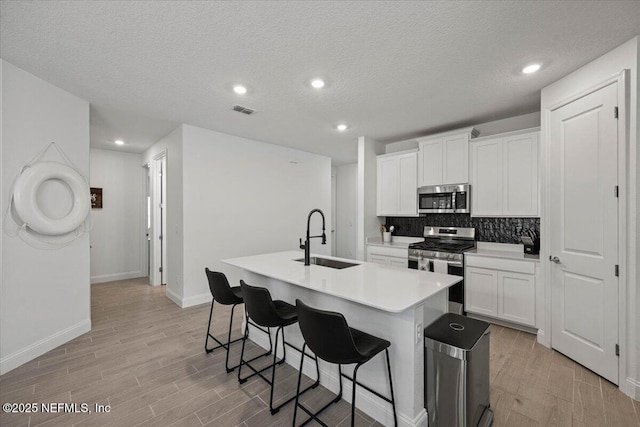 50 Dollar Ct, Saint Augustine, FL 32092 - kitchen with appliances with stainless steel finishes, a sink, a breakfast bar, a center island with sink, and tasteful backsplash