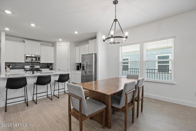 50 Dollar Ct, Saint Augustine, FL 32092 - dining space featuring a chandelier, light wood-type flooring, baseboards, recessed lighting, and a textured ceiling
