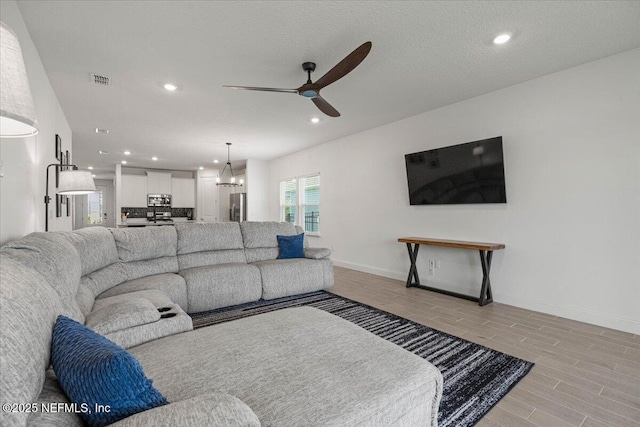 50 Dollar Ct, Saint Augustine, FL 32092 - living area featuring a ceiling fan, recessed lighting, light wood-style floors, baseboards, and a chandelier