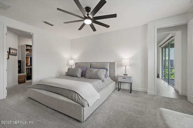 50 Dollar Ct, Saint Augustine, FL 32092 - carpeted bedroom featuring baseboards, a textured ceiling, a spacious closet, and a ceiling fan