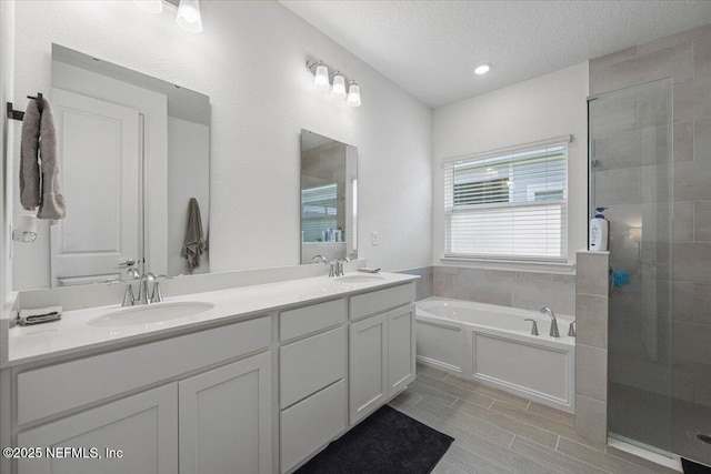50 Dollar Ct, Saint Augustine, FL 32092 - full bathroom featuring a bath, double vanity, a stall shower, a textured ceiling, and wood tiled floors