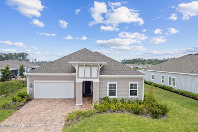 85541 Stonehurst Pkwy, Fernandina Beach, FL 32034 - traditional-style house featuring a front yard, an attached garage, decorative driveway, and a shingled roof