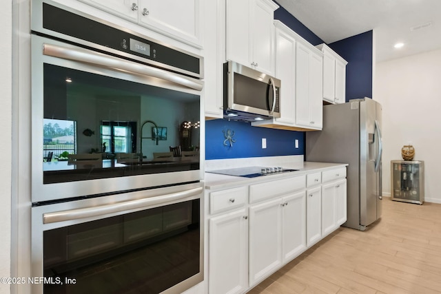 85541 Stonehurst Pkwy, Fernandina Beach, FL 32034 - kitchen with appliances with stainless steel finishes, white cabinetry, light countertops, light wood-style flooring, and recessed lighting