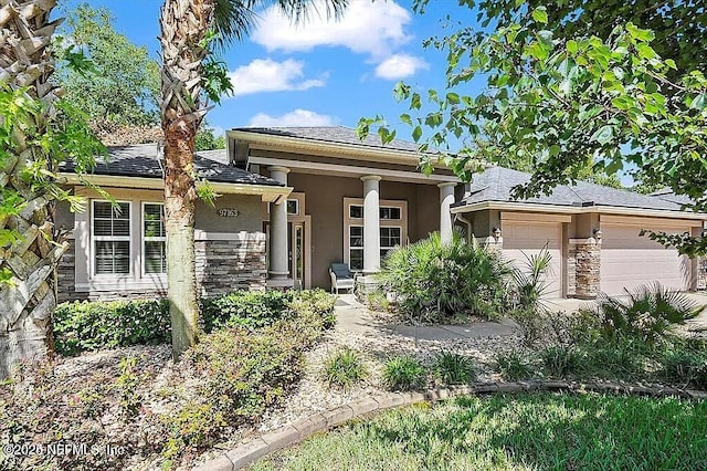 97163 Bluff View Cir, Yulee, FL 32097 - view of front of home with stone siding, stucco siding, an attached garage, and a shingled roof