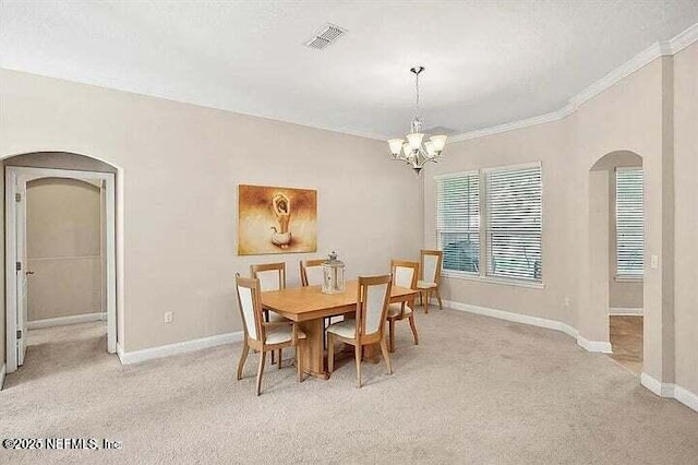 97163 Bluff View Cir, Yulee, FL 32097 - dining space featuring arched walkways, light carpet, crown molding, and a chandelier