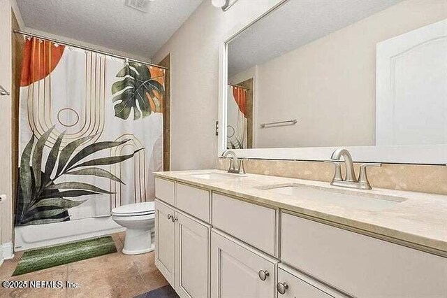 97163 Bluff View Cir, Yulee, FL 32097 - bathroom featuring double vanity, a shower with shower curtain, tile patterned floors, and a textured ceiling