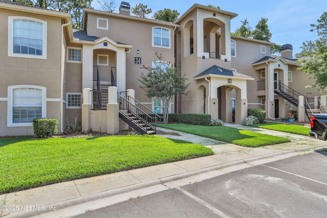 1655 The Greens Way Unit 3416, Jacksonville Beach, FL 32250 - multi unit property with stucco siding, uncovered parking, a chimney, and a front lawn