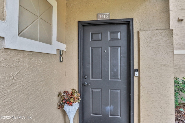 1655 The Greens Way Unit 3416, Jacksonville Beach, FL 32250 - view of exterior entry featuring stucco siding