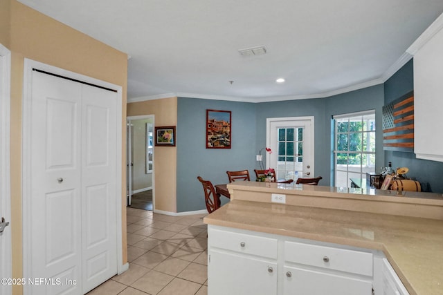 1655 The Greens Way Unit 3416, Jacksonville Beach, FL 32250 - kitchen featuring white cabinetry, light countertops, light tile patterned flooring, ornamental molding, and a peninsula