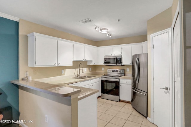 1655 The Greens Way Unit 3416, Jacksonville Beach, FL 32250 - kitchen featuring stainless steel appliances, a sink, a peninsula, white cabinets, and light tile patterned floors