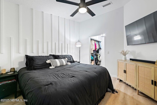 2275 Fairway Villas Ln N, Atlantic Beach, FL 32233 - bedroom featuring light wood-style floors, a closet, a ceiling fan, and a walk in closet
