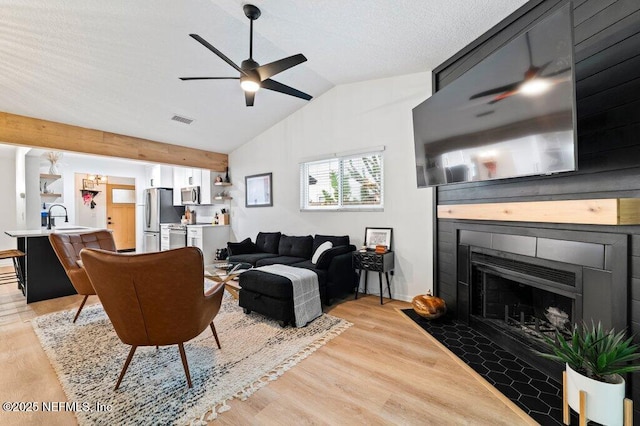 2275 Fairway Villas Ln N, Atlantic Beach, FL 32233 - living area featuring ceiling fan, a fireplace with flush hearth, light wood-style floors, and vaulted ceiling