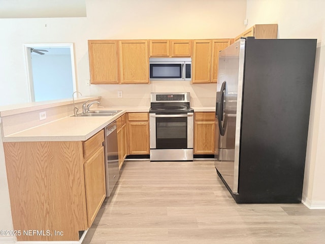 312 Turtle Dove Dr, Orange Park, FL 32073 - kitchen featuring appliances with stainless steel finishes, a sink, a peninsula, light wood-style floors, and light countertops