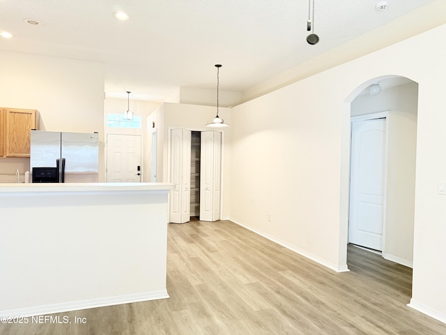 312 Turtle Dove Dr, Orange Park, FL 32073 - kitchen with stainless steel fridge with ice dispenser, light wood-type flooring, baseboards, recessed lighting, and arched walkways
