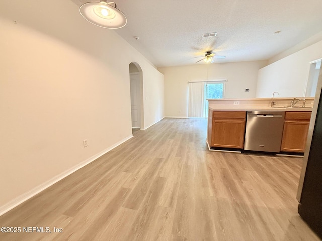 312 Turtle Dove Dr, Orange Park, FL 32073 - kitchen featuring dishwasher, a ceiling fan, arched walkways, brown cabinets, and light wood-style floors
