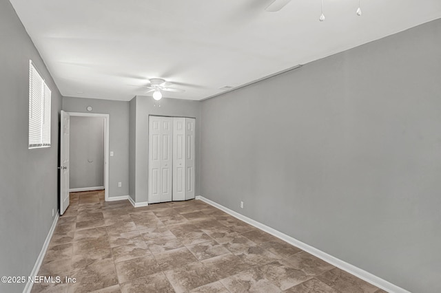 7439 Elvia Dr, Jacksonville, FL 32211 - unfurnished bedroom featuring baseboards, a closet, ceiling fan, and stone finish flooring