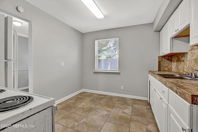 7439 Elvia Dr, Jacksonville, FL 32211 - kitchen featuring a sink, decorative backsplash, white cabinets, white electric range oven, and baseboards