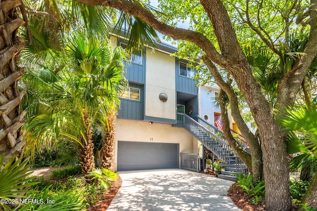 2279 Seminole Rd Unit 11, Atlantic Beach, FL 32233 - view of building exterior with stairs, concrete driveway, and a garage