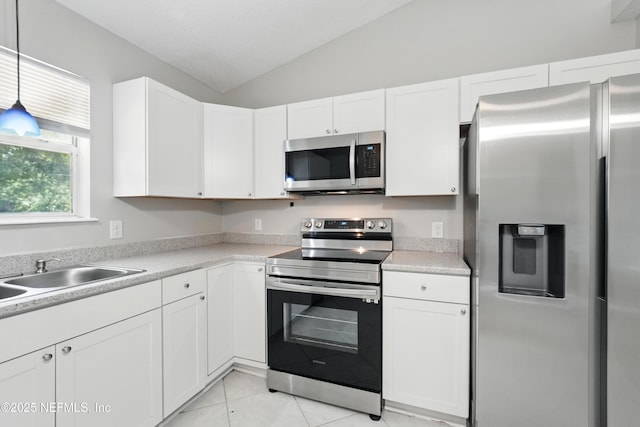 257 Jasmine St, Atlantic Beach, FL 32233 - kitchen featuring appliances with stainless steel finishes, vaulted ceiling, white cabinets, a sink, and light countertops