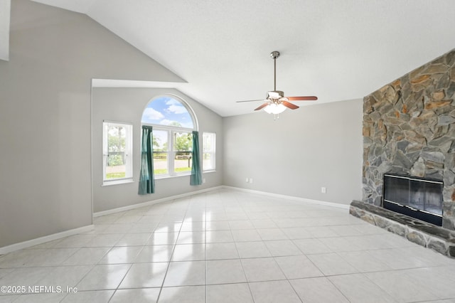 257 Jasmine St, Atlantic Beach, FL 32233 - unfurnished living room featuring vaulted ceiling, a ceiling fan, a stone fireplace, light tile patterned floors, and baseboards