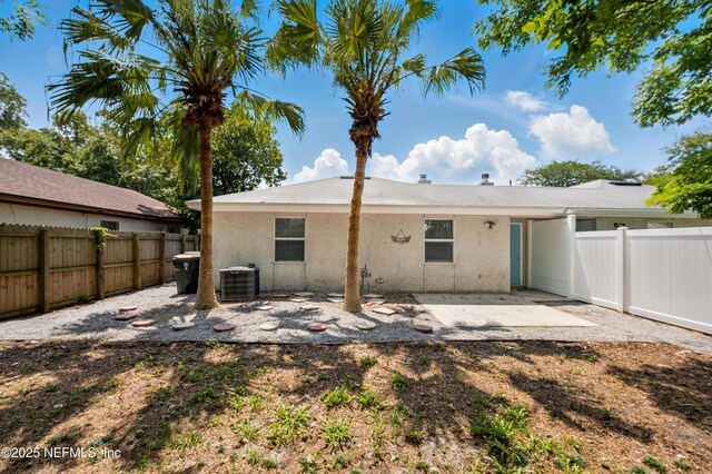 257 Jasmine St, Atlantic Beach, FL 32233 - rear view of house featuring cooling unit, a fenced backyard, and stucco siding