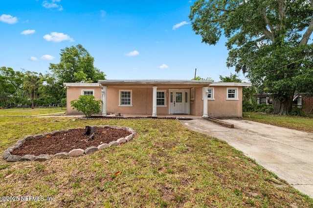 17 Rollins Ave, Saint Augustine, FL 32084 - ranch-style house with stucco siding, a front yard, covered porch, and concrete driveway