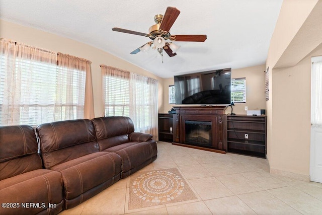 17 Rollins Ave, Saint Augustine, FL 32084 - living room with a glass covered fireplace, a ceiling fan, light tile patterned floors, vaulted ceiling, and baseboards