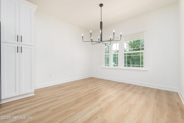1873 Openwoods Rd, Middleburg, FL 32068 - unfurnished dining area with a chandelier, light wood-style floors, and baseboards
