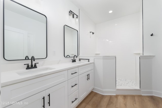 1873 Openwoods Rd, Middleburg, FL 32068 - bathroom with a walk in shower, double vanity, wood finished floors, baseboards, and recessed lighting