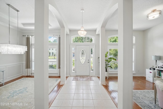 784 Mill Stream Rd, Ponte Vedra Beach, FL 32082 - entryway featuring a chandelier, arched walkways, a textured ceiling, and light wood finished floors