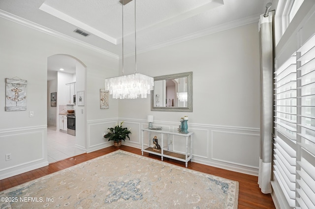 784 Mill Stream Rd, Ponte Vedra Beach, FL 32082 - dining space with wood finished floors, arched walkways, a chandelier, and crown molding