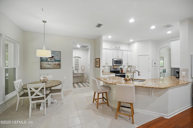 784 Mill Stream Rd, Ponte Vedra Beach, FL 32082 - kitchen with stainless steel appliances, a sink, a kitchen breakfast bar, light stone counters, and recessed lighting