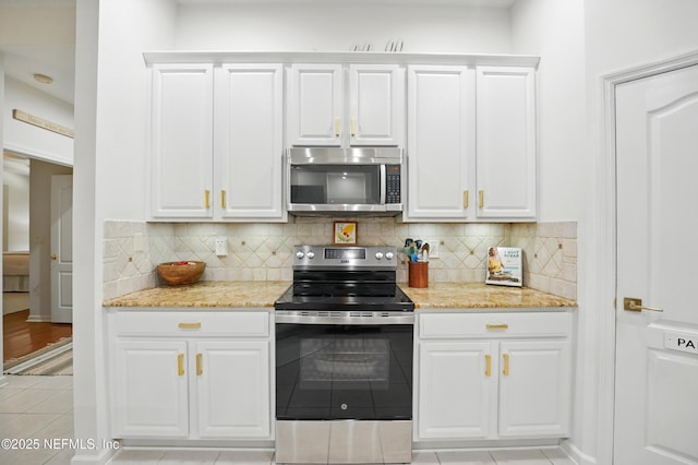 784 Mill Stream Rd, Ponte Vedra Beach, FL 32082 - kitchen featuring stainless steel appliances, light tile patterned floors, white cabinets, and decorative backsplash