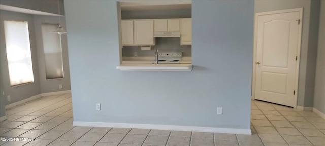 2340 Commodores Club Blvd, Saint Augustine, FL 32080 - kitchen with range, light countertops, baseboards, under cabinet range hood, and white cabinets