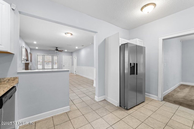 4537 Springfield Blvd, Jacksonville, FL 32206 - kitchen with stainless steel appliances, white cabinets, light tile patterned floors, a textured ceiling, and a ceiling fan