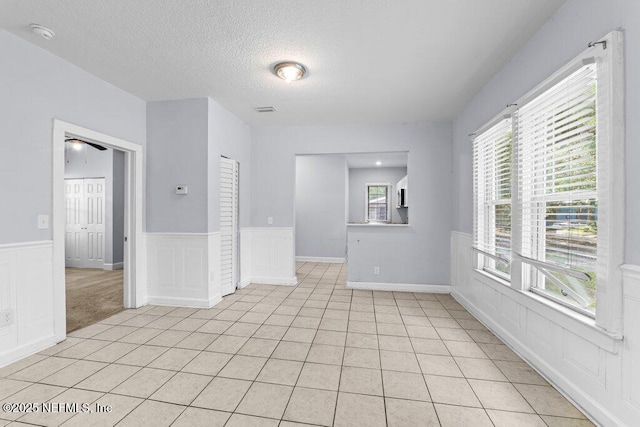 4537 Springfield Blvd, Jacksonville, FL 32206 - spare room with a textured ceiling, wainscoting, light tile patterned floors, ceiling fan, and a smoke detector